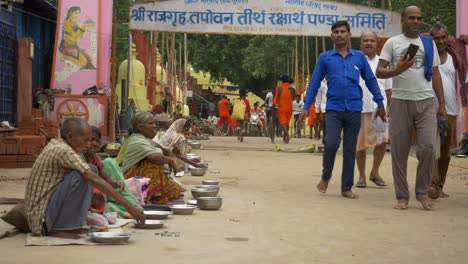 Eine-Gruppe-Armer-Inder-Bettelt-Vor-Dem-Gelände-Des-Hinduistischen-Tempels-Um-Essen-Und-Geld,-Hinduistische-Anhänger-Spenden-Den-Bettlern-Geld