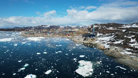 Ciudad-Remota-En-Groenlandia-Con-Icebergs-Flotantes,-Vista-Aérea-Ascendida