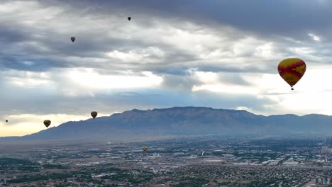 Hot-air-balloons-flying-over-Albuquerque,-New-Mexico-city-and-landscape-during-annual-balloon-festival
