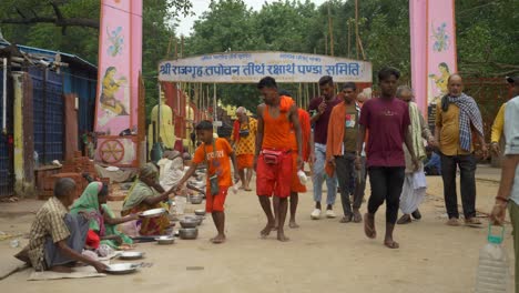 Poor-Indian-people-begging-for-food-and-money-outside-the-Hindu-temple-premises,-Hindu-devotees-donating-money-to-the-beggars