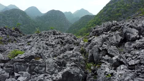 Impressive-rock-formations-foreground,-stunning-mountain-range-background,-Vietnam