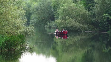 Boat-floating-upriver-in-a-calm-river-Nore-in-Kilkenny-city-on-a-warm-September-day