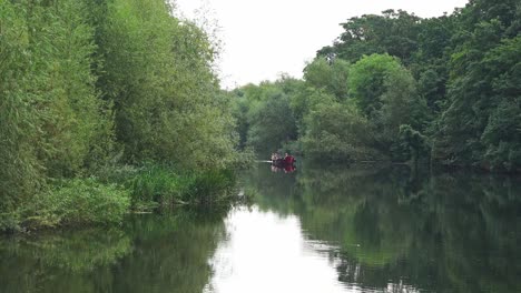 Boat-lazily-floating-upriver-on-The-River-Nore-in-Kilkenny-City-on-a-summer-morning