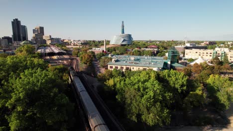 Aerial-clip-of-Via-Rail-train-entering-the-Forks-in-Winnipeg,-MB