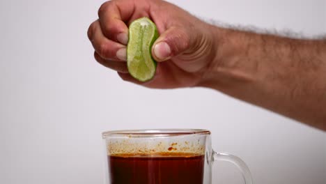 Person-squeezing-lime-into-consome-birria-cup
