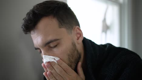 Young-white-man-sick-at-home-with-Covid,-coughing,-blowing-nose
