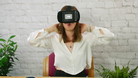 Eine-Glückliche-Junge-Berufstätige-Frau,-Die-In-Einem-Büro-Ein-VR-Virtual-Reality-Headset-Aufsetzt