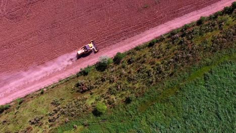 Vista-Aérea-De-Un-Tractor-Agrícola-Sobre-Campos-De-Soja-Cosechados-Cerca-Del-Bosque-Amazónico-En-Brasil.