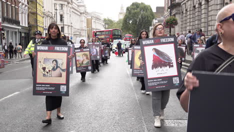 Los-Manifestantes-Marchan-Por-Whitehall-Sosteniendo-Pancartas-Que-Representan-A-Mahsa-Amini-Y-Otras-Personas-Que-Han-Sido-Asesinadas-En-Protestas-Por-Los-Derechos-De-Las-Mujeres-En-Irán.