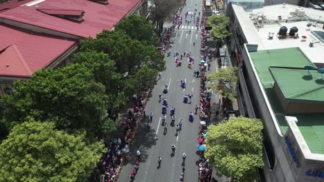 Parade-Zum-Unabhängigkeitstag-Von-Costa-Rica,-Hohe-Drohnenaufnahme-über-Blaskapellen-Und-Tanzende-Kinder-In-Traditioneller-Kleidung