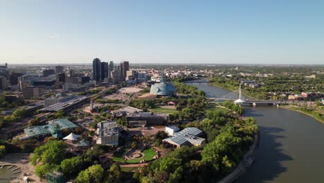 Panoramic-aerial-of-downtown-Winnipeg,-Red-River-and-the-Forks,-4K