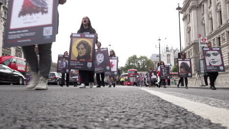 Los-Manifestantes-Marchan-Por-Whitehall-Mientras-Sostienen-Pancartas-Que-Representan-A-Mahsa-Amini-Y-Otras-Personas-Que-Han-Sido-Asesinadas-En-Protestas-Por-Los-Derechos-De-Las-Mujeres-En-Irán.