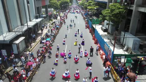 Drone-Volando-Sobre-Escolares-Con-Vestidos-Tradicionales-Durante-El-Desfile-Del-Día-De-La-Independencia-De-Costa-Rica