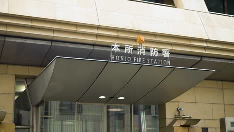 Hand-held-shot-of-the-Honjo-Fire-Station-sign-in-downtown-Toyko,-Japan
