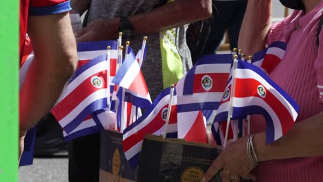 Mujer-Vendiendo-Banderas-Costarricenses-En-Miniatura-Durante-El-Desfile-Del-Día-De-La-Independencia-De-Costa-Rica