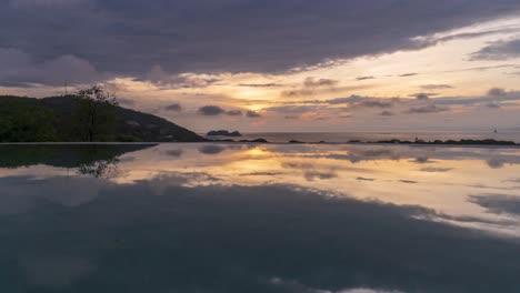 Low-angle-time-lapse-of-ocean-water-reflecting-stunning-sky-and-clouds-at-blue-hour-dusk