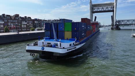 The-Amazone-sailing-on-the-Oude-Maas-river-at-the-city-of-Dordrecht,-cinematic