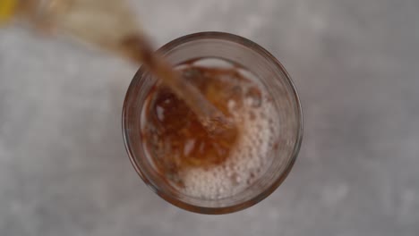 Pouring-Carbonated-Peach-Ice-Tea-Into-Glass-Top-View