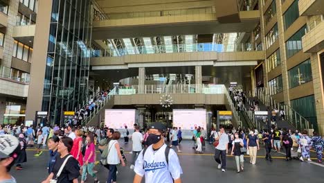 Toma-De-Inclinación-Lenta-Que-Muestra-A-Los-Viajeros-Caminando-Por-La-Estación-De-Tren-De-Osaka,-Japón.