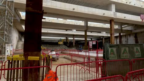 Barandillas-De-Seguridad-Rojas-Con-Vista-A-La-Excavadora-Quitando-Roca-Y-Arcilla-En-Viejos-Túneles-Profundos-Comunes-De-Roble-En-El-Fondo