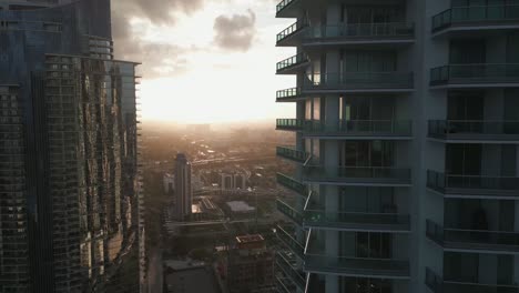 Drones-Aéreos-Vuelan-Alrededor-De-Balcones-De-Cristal-De-Rascacielos-En-El-Centro-De-Miami,-Fondo-Del-Horizonte-Al-Atardecer