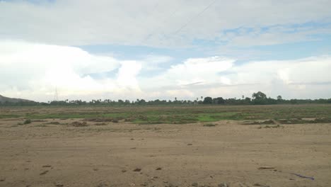 Panoramic-view-of-sacred-Falgu-River-dry-waterbed-with-a-long-stretch-of-sand-dunes-under-clear-sky,-Bodhgaya,-Bihar,-India