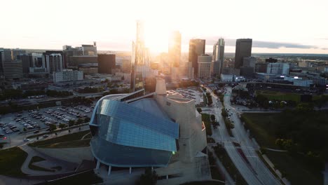 Una-Puesta-De-Sol-Reflejo-Brillante-Hora-Dorada-Vista-Aérea-Del-Parque-Urbano-Museo-Canadiense-De-Derechos-Humanos-El-Mercado-De-Horquillas-Centro-De-Winnipeg-Parque-Shaw-Puente-Provencher-Río-Rojo-En-Manitoba-Canadá