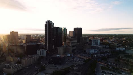 Ein-Aufsteigender-Wolkenkratzer,-Sonnenuntergang,-Goldene-Stunde,-Luftaufnahme-Des-Stadtparks,-Kanadisches-Museum-Für-Menschenrechte,-The-Forks-Market,-Innenstadt-Von-Winnipeg,-Shaw-Park,-Provencher-Bridge,-Red-River-In-Manitoba,-Kanada