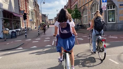 Toma-De-Movimiento-Siguiendo-A-Una-Joven-Adolescente-En-Bicicleta-En-El-Centro-De-La-Ciudad-De-Haarlem-En-Los-Países-Bajos.