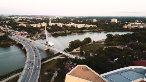 Ein-Sonnenuntergang,-Goldene-Stunde,-Luftaufnahme-Des-Stadtparks,-Kanadisches-Museum-Für-Menschenrechte,-The-Forks-Market,-Innenstadt-Von-Winnipeg,-Shaw-Park,-Provencher-Steel-Bridge,-Red-River-In-Manitoba,-Kanada,-Sommerzeit