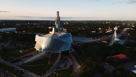 An-Orbit-Sunset-Golden-Hour-Aerial-View-of-the-Urban-Park-Canadian-Museum-for-Human-Rights-The-Forks-Market-Downtown-Winnipeg-Shaw-Park-Provencher-Bridge-Red-River-in-Manitoba-Canada