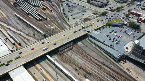 Aerial-view-following-a-AMTRAK-train,-driving-through-the-sunny-Chicago-Car-Yard