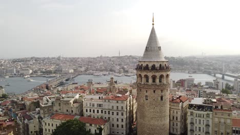 Sunny-aerial-view-of-galata-tower-in-beyoglu-istanbul-with-bosphorus-sea,-mosques,-galata-bridge-in-the-background-behind