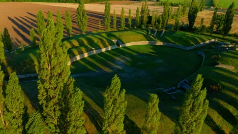 Ruins-Of-The-Ancient-Amphitheater-Of-Carnuntum-In-Austria-At-Sunset---aerial-drone-shot