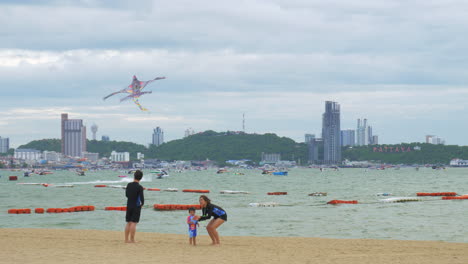 Happy-parents-and-their-children-playing-with-kites-on-the-beach-near-the-sea