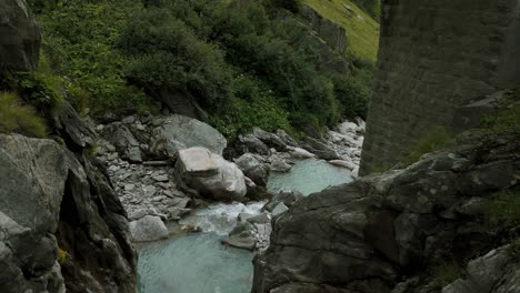 Cinematic-view-of-Furka-Pass-valley-and-river-stream-flowing-in-Switzerland
