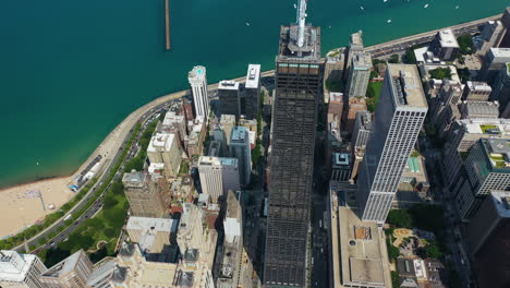 Aerial-view-tilting-away-from-the-875-North-Michigan-Avenue,-in-sunny-Chicago,-USA
