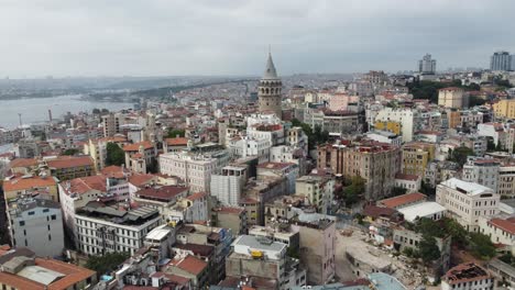 Drone-video-of-galata-tower-in-beyoglu-istanbul-with-city-buildings,-roofs,-the-bosphorus-and-city-view