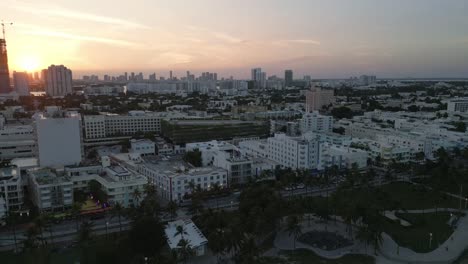 drone-revealing-ocean-drive-road-with-bar-club-and-restaurant-in-Miami-South-beach-during-sunset