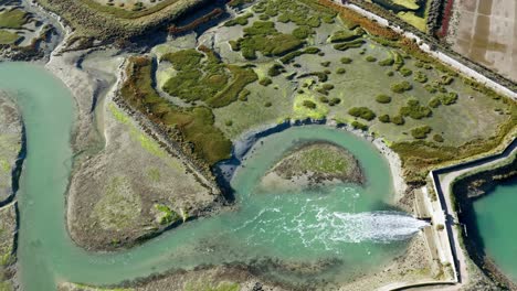 Aerial-View-Of-Water-Released-Through-A-Dam-On-The-Nature-Reserve,-Ile-de-Ré,-France