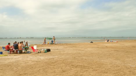 Gente-Relajándose-En-La-Playa-Del-Delta-Durante-El-Verano-En-El-Delta-Del-Ebro,-Cataluña,-España