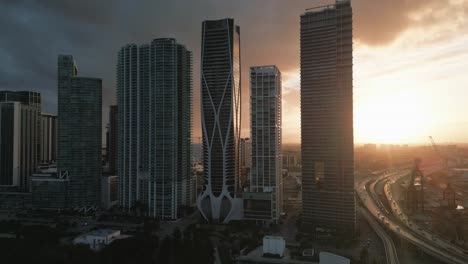 Horizonte-Dorado-Del-Atardecer-Sobre-Los-Vibrantes-Rascacielos-De-Miami-El-Centro-De-La-Ciudad-Drone-Aéreo-Vuela-Sobre-La-Arquitectura-De-La-Ciudad-Moderna-Estadounidense