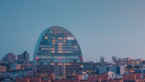 Nahaufnahme-Des-BBVA-Gebäudes-Tag-Nacht-Zeitraffer-Der-Modernen-Stadt-Madrid-Bei-Farbenprächtigem-Sonnenuntergang-Mit-Bewegten-Wolken,-Skyline-Der-Stadt-Vom-Aussichtspunkt-Las-Tablas-Aus