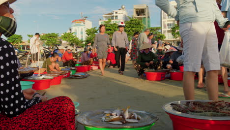 Halbnahe-Ansicht-Von-Frauen-Auf-Dem-Fischmarkt,-Die-Ausnehmen-Und-Putzen,-Während-Die-Einheimischen-Auf-Der-Suche-Nach-Frischen-Lebensmitteln-Sind