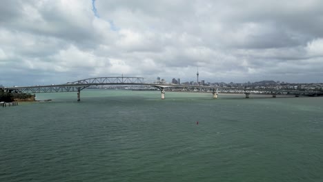 Scenic-Views-of-Auckland-Harbour-Bridge-and-Downtown-over-Waitemata-Harbour-with-an-Aerial-Dolly-Out-Shot,-New-Zealand