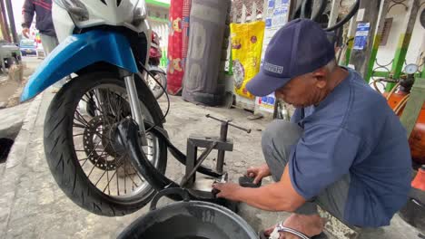 Prozess-Der-Reparatur-Und-Des-Austauschs-Von-Motorradreifen-Durch-Einen-Männlichen-Techniker-In-Indonesien