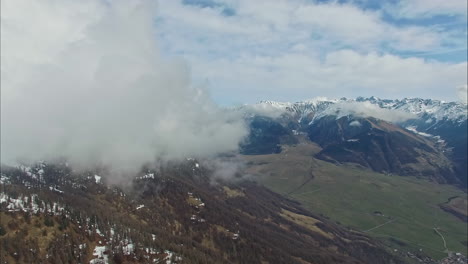 Luftaufnahmen-Der-Bergkette-Mit-Schneebedeckter-Bergkette-Und-Tief-Hängenden-Wolken