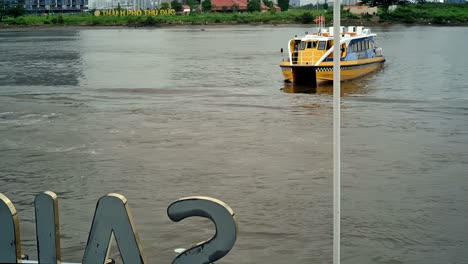 A-"waterbus"-ferrying-passengers-and-tourists-conducts-its-docking-maneuver-at-one-of-the-stations-along-the-Saigon-River-in-Ho-Chi-Minh-City,-Vietnam