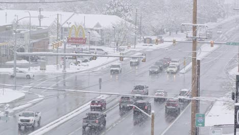 A-busy-intersection-with-cars-turning-left-and-others-waiting-during-a-cold-snowstorm-causing-slick-roads-in-December-of-2022-in-Midvale,-Utah