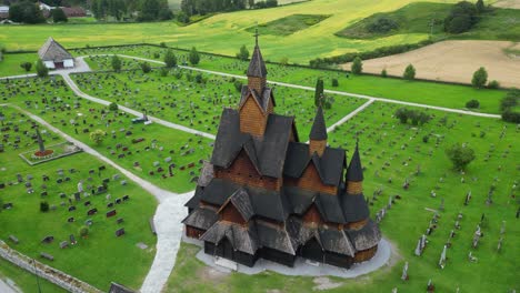 Heddal-Stave-Church-and-Headstones-in-Vestfold-og-Telemark,-Norway,-Scandinavia---Aerial